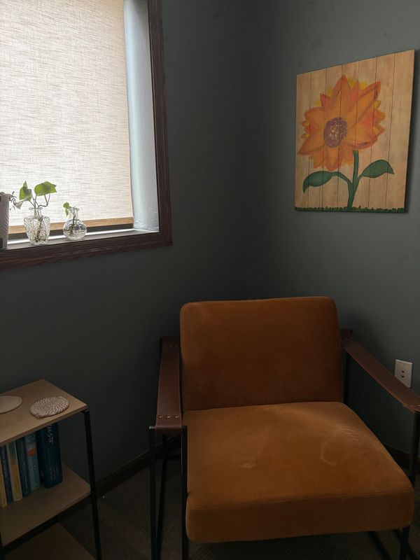 Cozy corner with mustard chair and sunflower painting.