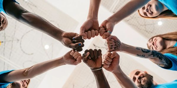 Diverse team bumping fists together.