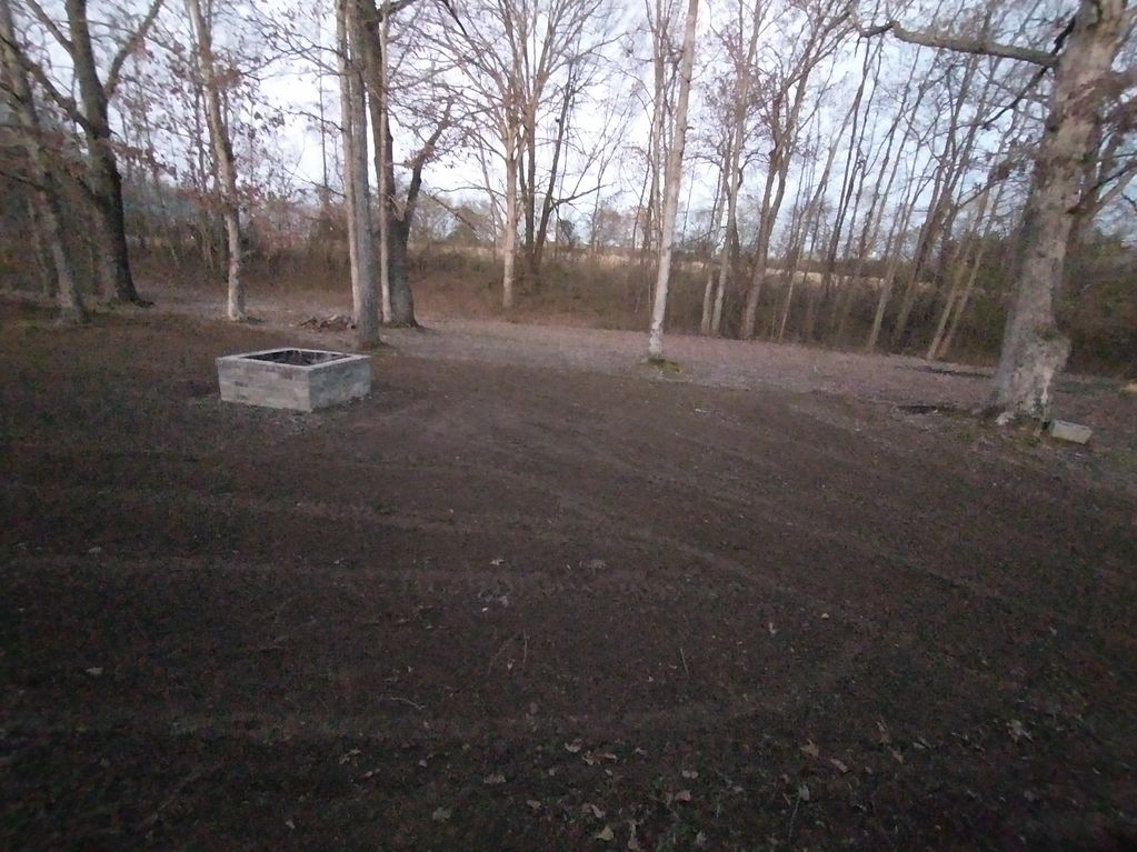 Backyard that had gravel and patchy grass after being redone.