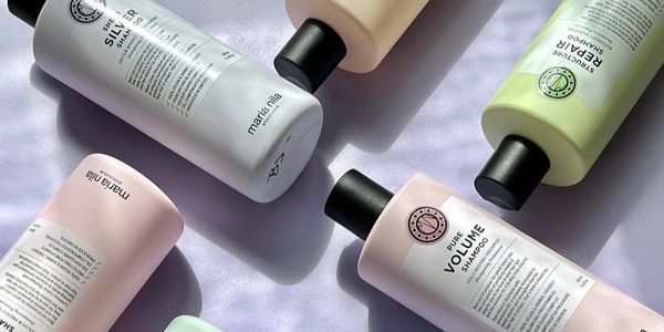 Assorted Maria Nila hair care bottles arranged on a light surface.