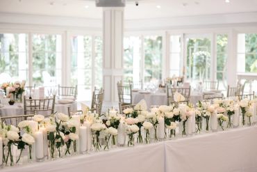 Elegant wedding table decorated with white flowers and candles.