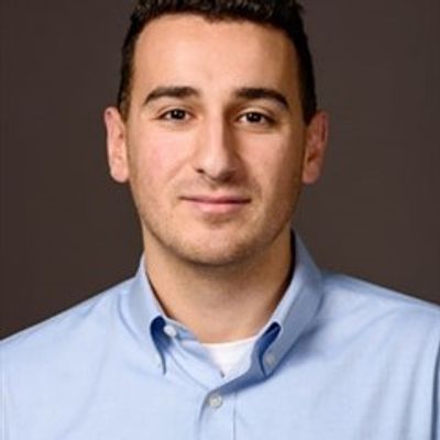 Portrait of a man in a blue shirt.