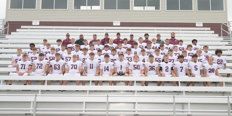 High school football team photo in stadium stands.