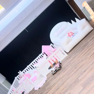 A pink and white themed kids' playroom with furniture and toys.