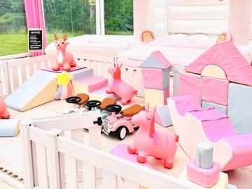 Bright and playful pink-themed kids' play area with toys.
