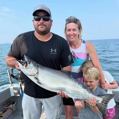 Family holding a large fish on a boat.