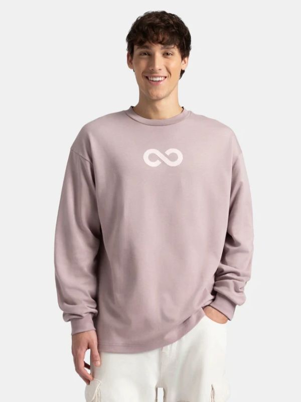 Smiling young man in a mauve sweater with an infinity symbol paired with white pants.