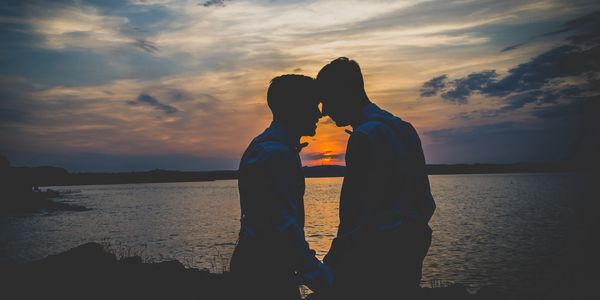 Couple posing with sunset behind
