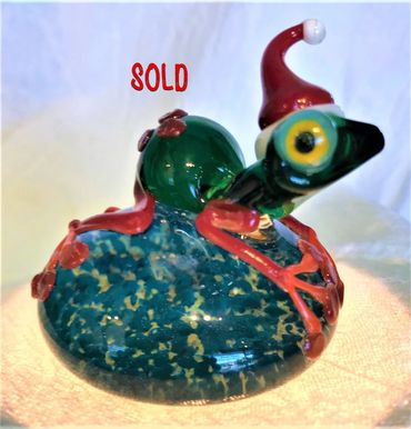 Santa's helper frog paper weight made of hand blown glass. 
