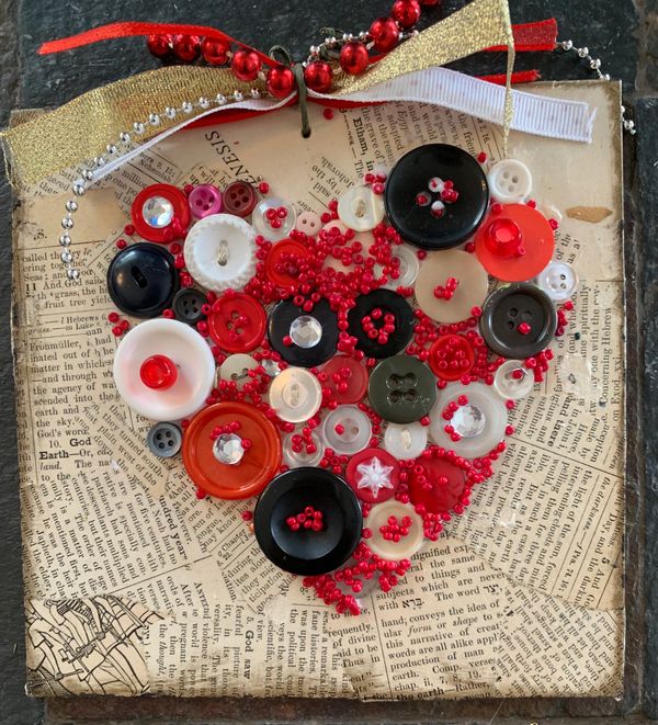 Vintage book paper 6x6 square base with red, white and black buttons in the shape of a heart. 