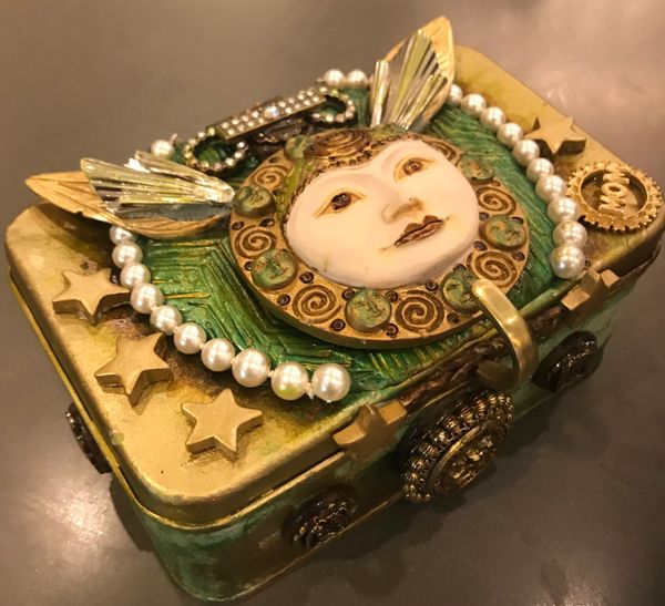 Clay covered metal box with head and wings. Green and gold colors with pearls