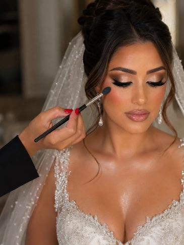 Bride getting makeup applied with a brush.
