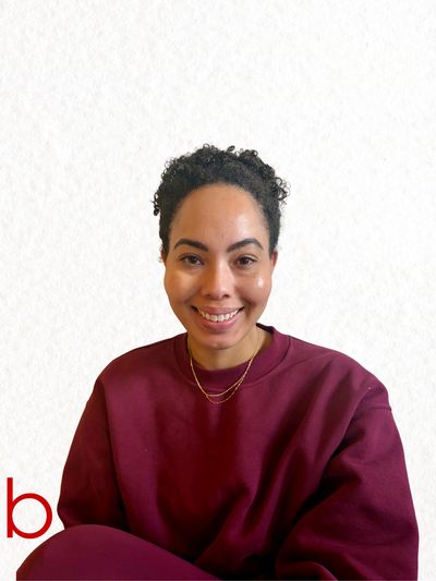 Smiling woman in a burgundy sweatshirt against a plain white background.