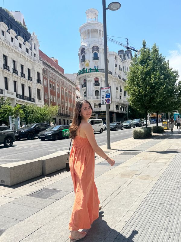 Mujer caminando por la ciudad con vestido naranja.