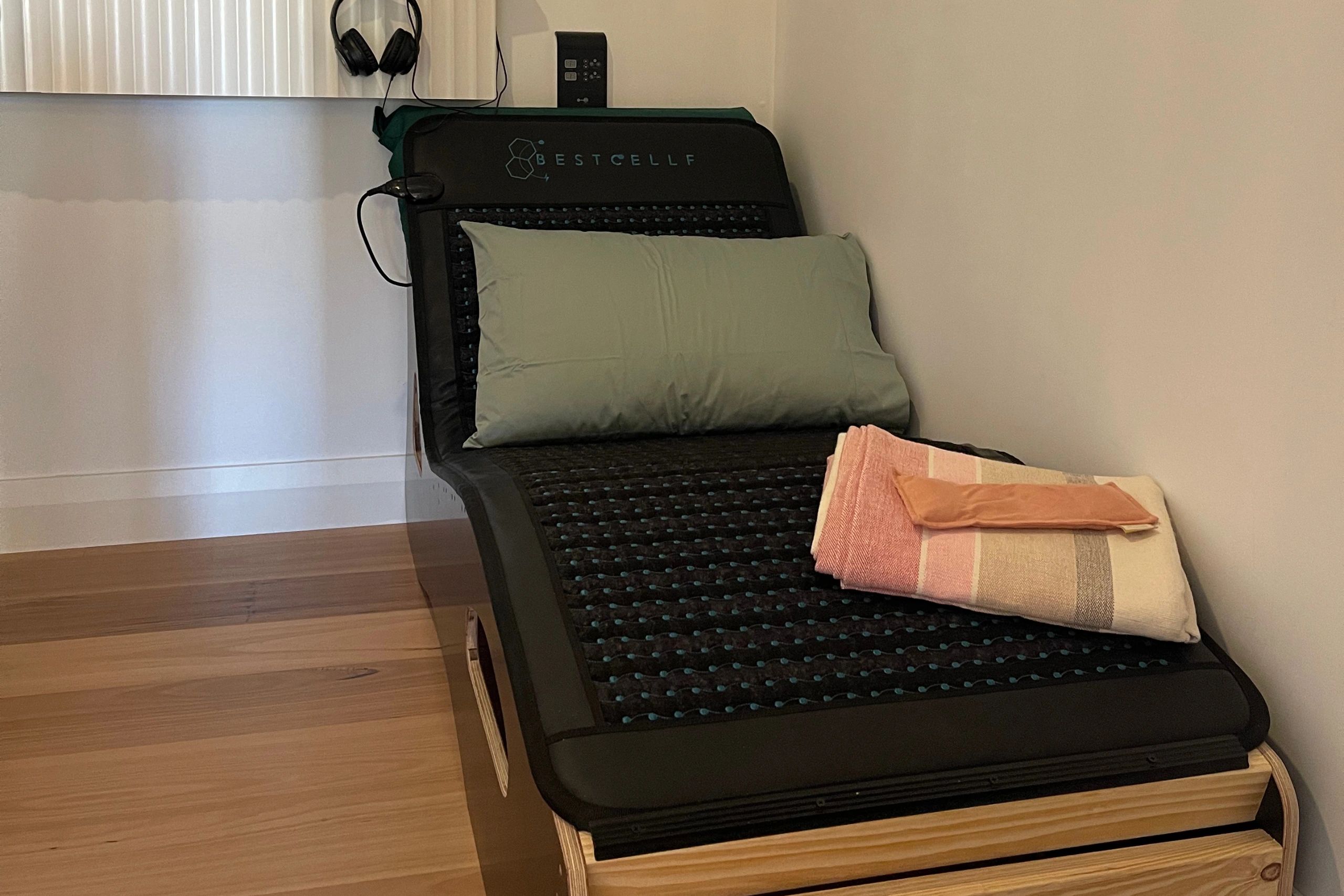 Black cushioned lounge chair with pillow and folded towels.