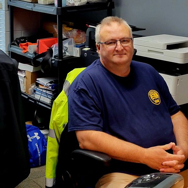 Two people sitting in an office, smiling at the camera.