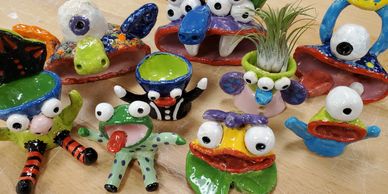 Colorful, quirky clay monster sculptures with big eyes and expressive faces.