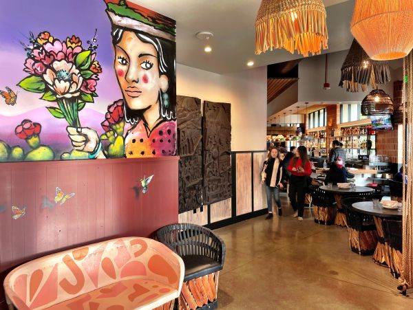 Colorful mural and cozy seating in a vibrant cafe interior.