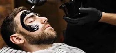 Man getting a black facial treatment at a spa.