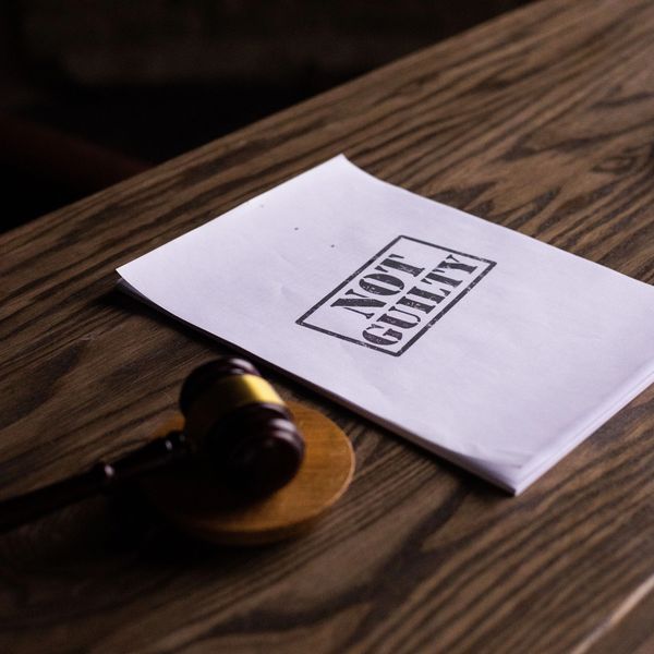 Document stamped 'Not Guilty' on a wooden table with a gavel.