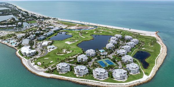 Aerial view of a coastal resort with multiple buildings and a golf course.