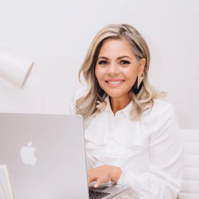 Smiling woman working on a laptop.
