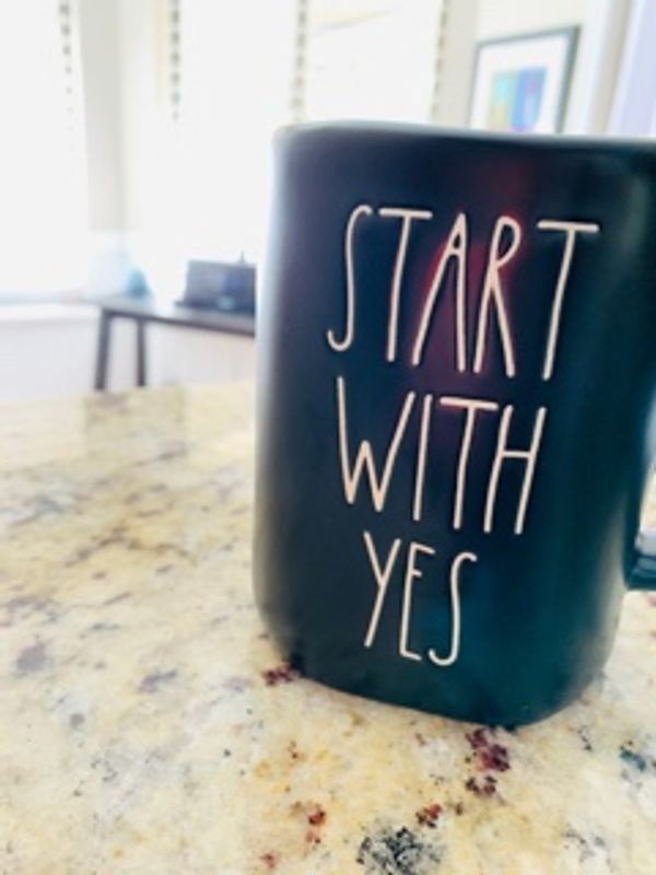 Black mug with the words 'START WITH YES'.