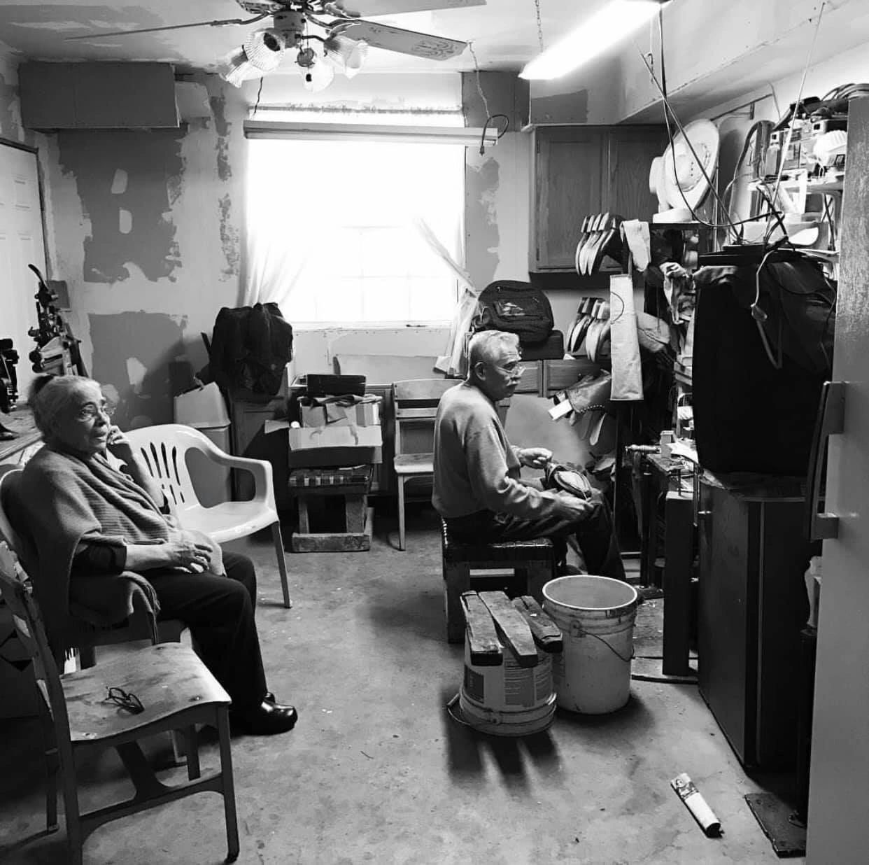 Juan Cruz at his bench in the family shop in El Paso, 2017, with his wife seated nearby