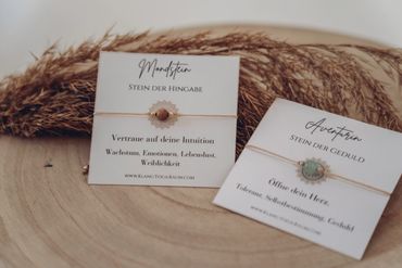 Two delicate bracelets on cards with German inscriptions about stones and virtues.