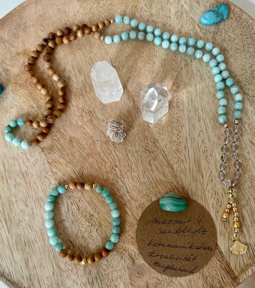 Beaded jewelry with crystals on a wooden surface.