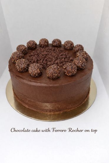 Chocolate cake decorated with Ferrero Rocher chocolates on top.