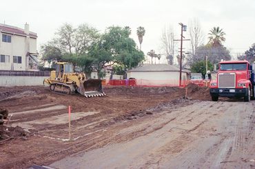 Bulldozer and truck at a construction site with cleared land.
