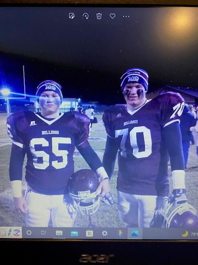 Two football players wearing Bulldogs uniforms and beanies.