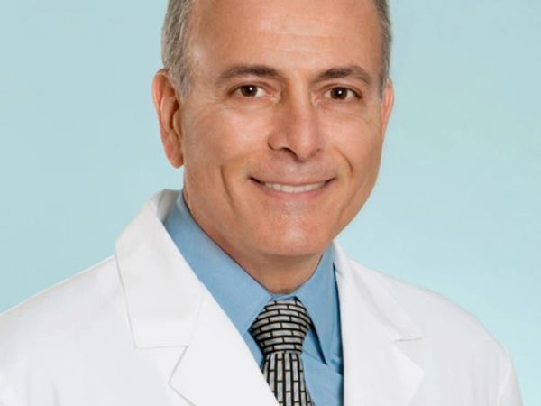 Smiling male doctor in a white coat and tie.