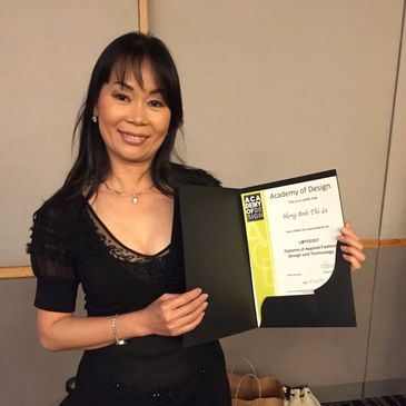 Woman proudly holding her diploma from the Academy of Design.