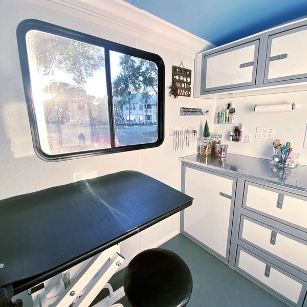 Interior of trailer . Large window, blue ceiling white walls hydraulic table 