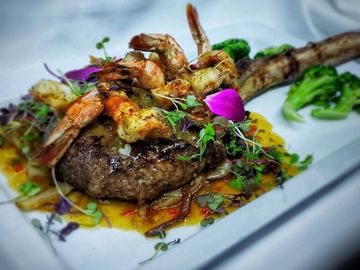 Extra large steak served with greens and topped with grilled shrimp. 