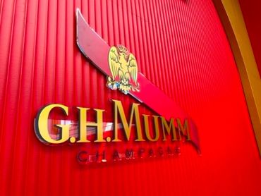 G.H. Mumm Champagne logo on red wall.