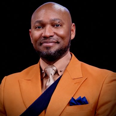Smiling man in an orange suit with a blue pocket square.