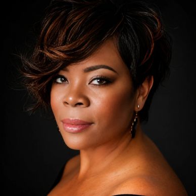 Portrait of a confident woman with styled hair and earrings.