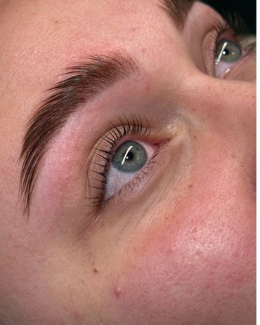 Close-up of a blue eye with well-groomed eyebrow and natural skin texture.