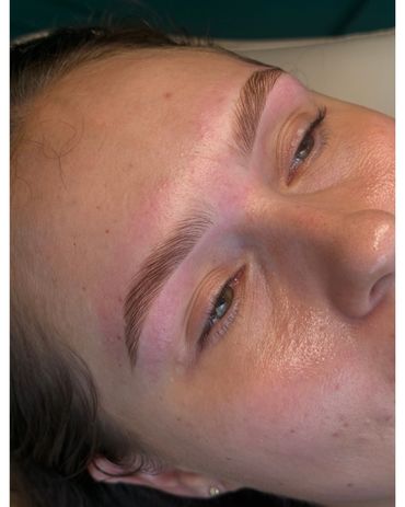 Close-up of freshly shaped eyebrows on a woman's face.