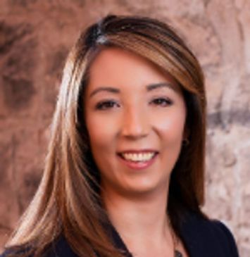 Professional headshot of a smiling woman with long hair.