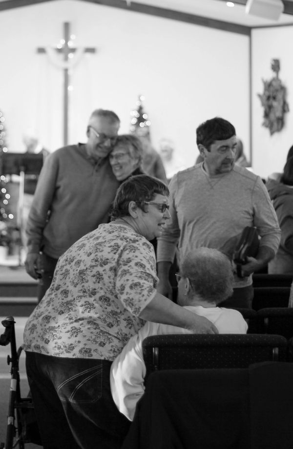 People interacting warmly inside a church.