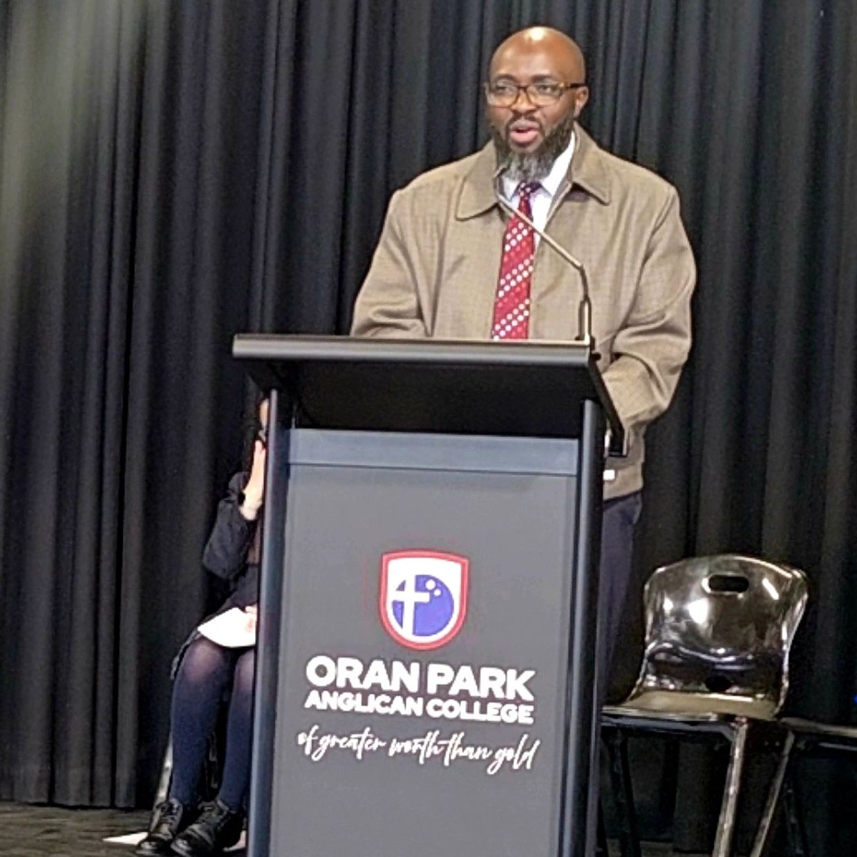 Man speaking at Oran Park Anglican College podium.