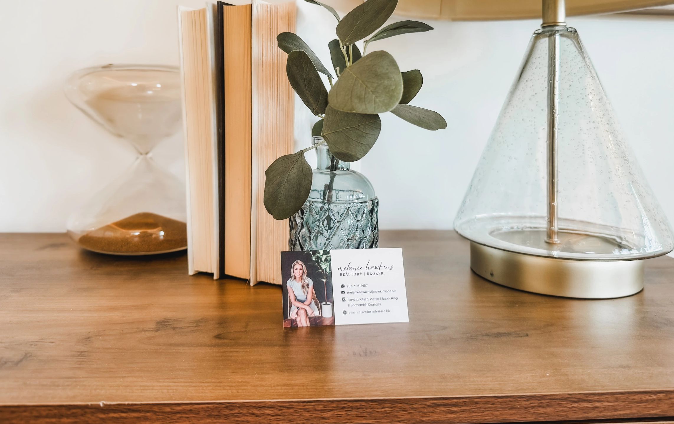Picture of Melanie Hawkins business card on a table inside a home
