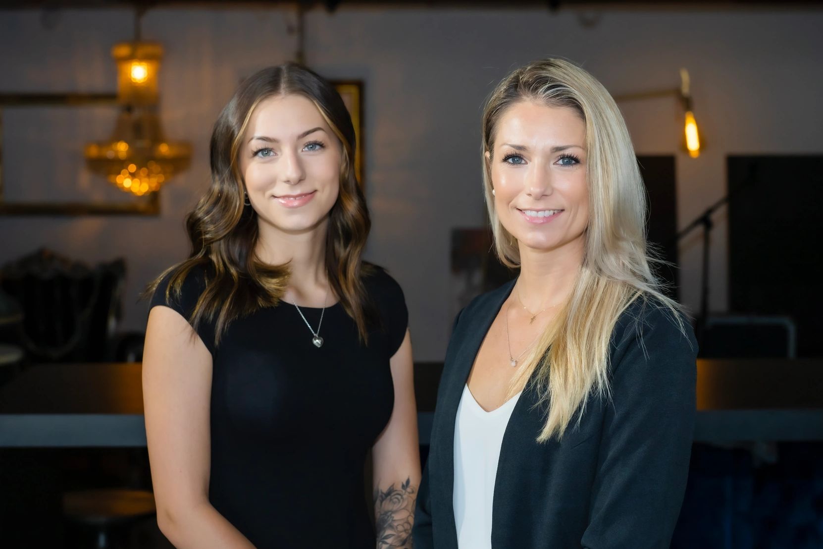 Two real estate agents posing fir a picture in a dark room