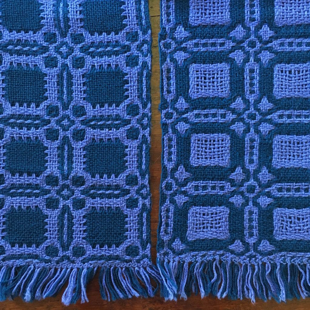 Close up of a fine woollen and cotton scarf woven in a reversible pattern in lilac and dark blue.