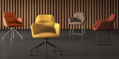 Four modern chairs in different colors arranged in a stylish room with wooden paneling.