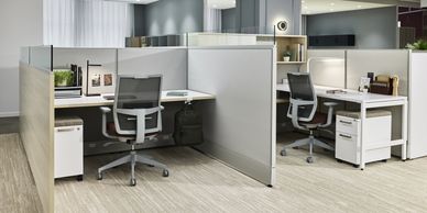 Modern office cubicles with ergonomic chairs and computers.